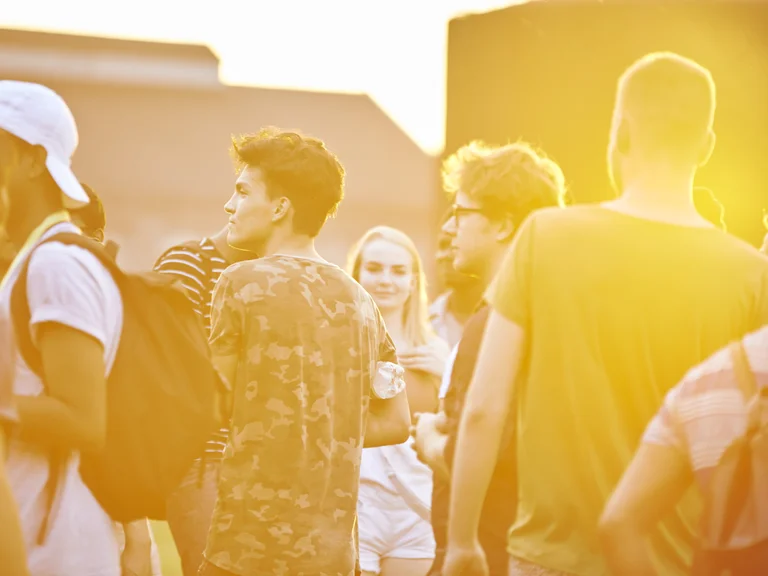 A group of young people illuminated by warm sunlight.