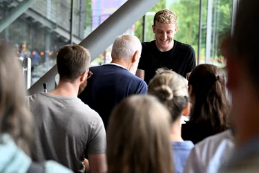 Das Bild zeigt eine Autogrammstunde mit Édouard Louis nach der ersten Veranstaltung „Brave New Voices“ in der Jahrhunderthalle Bochum im Rahmen der Ruhrtriennale 2024. Édouard Louis lächelt und unterhält sich mit einem Besucher, während eine Schlange von Menschen geduldig auf ihre Gelegenheit wartet, ein Autogramm zu bekommen. Die Atmosphäre ist entspannt und freundlich.