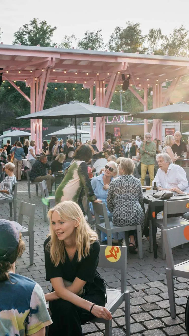 Großes Publikum im Festivalzentrum Wunderland, das sich bei strahlendem Sonnenschein angeregt unterhält.