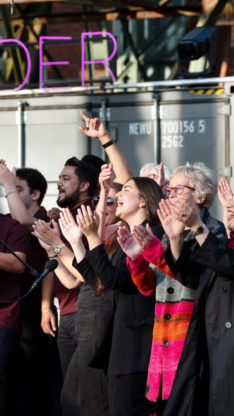 The Allerwelt Ensemble Duisburg in front of a shipping container bearing the word ‘Wunder’.