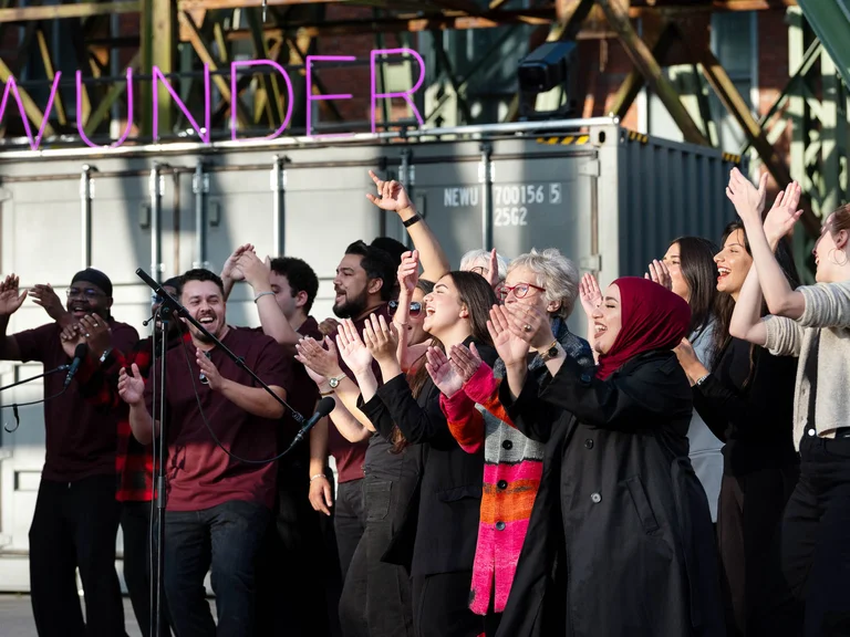 The Allerwelt Ensemble Duisburg in front of a shipping container bearing the word ‘Wunder’.