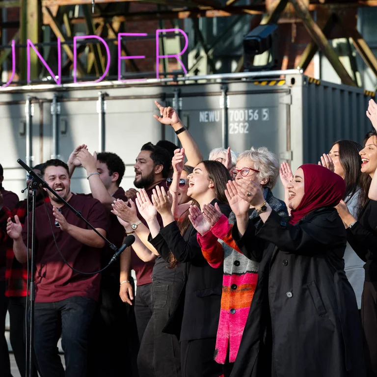 The Allerwelt Ensemble Duisburg in front of a shipping container bearing the word ‘Wunder’.