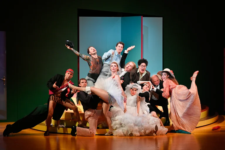 A group of people in costume on stage. They are putting on a performance.