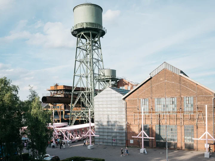 Ein alter Wasserturm ragt über das Festivalzentrum Wunderland, umgeben vom Bochumer Jahrhunderthallekomplex.