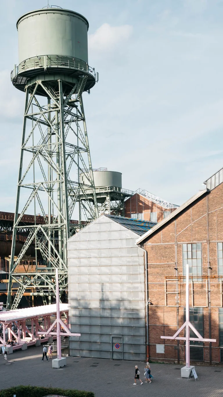 Ein alter Wasserturm ragt über das Festivalzentrum Wunderland, umgeben vom Bochumer Jahrhunderthallekomplex.