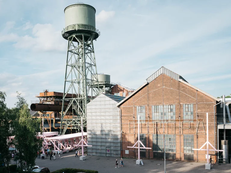 An old water tower towers over the Wunderland festival centre, surrounded by the Bochum Jahrhunderthalle complex.