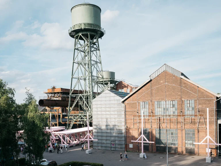 Ein alter Wasserturm ragt über das Festivalzentrum Wunderland, umgeben vom Bochumer Jahrhunderthallekomplex.