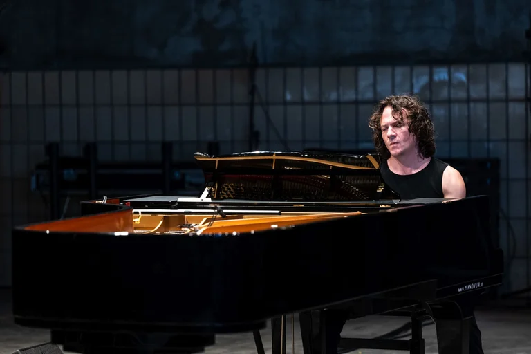 An artist from the group ‘Wild Up’ sits at the piano and plays music