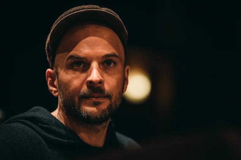 Ein Mann mit Hut schaut in die Kamera