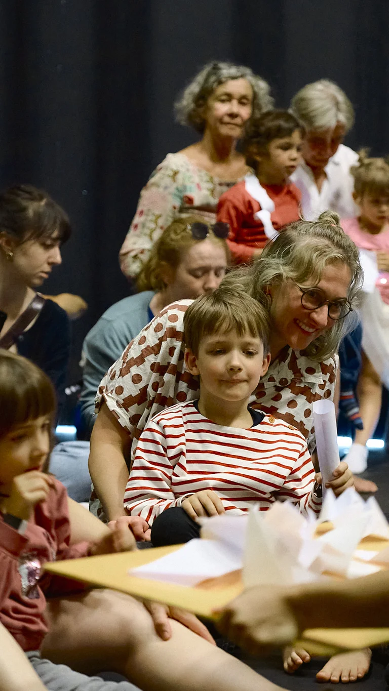 Erwachsene und Kinder sitzen dicht beieinander während der Vorstellung von "Club Origami" bei der Ruhrtriennale 2025.
