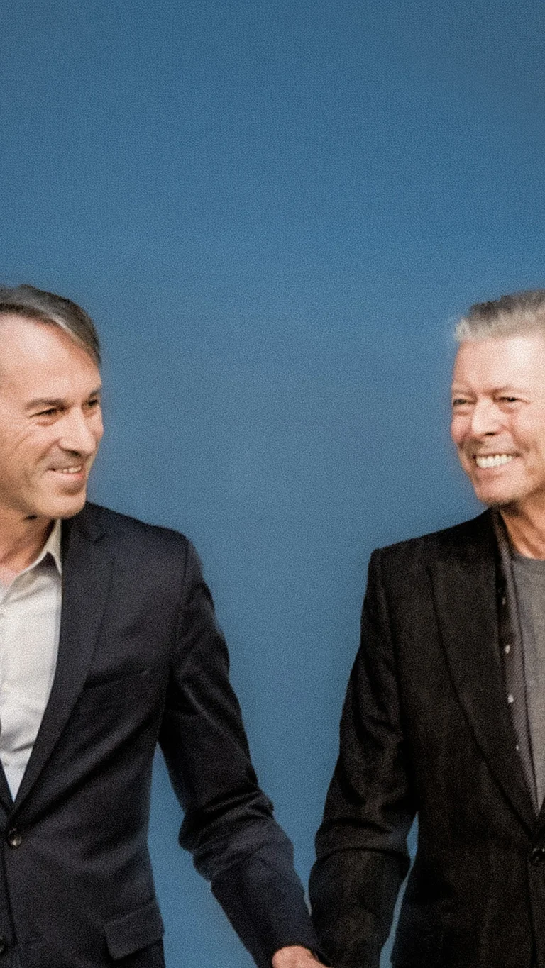 Ivo Van Hove mit David Bowie vor blauem Hintergrund