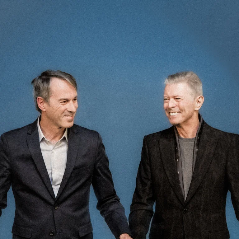 Ivo Van Hove mit David Bowie vor blauem Hintergrund