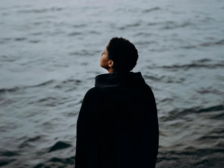 Singer-Songwriterin Meskerem Mees captures from behind, looking at water.