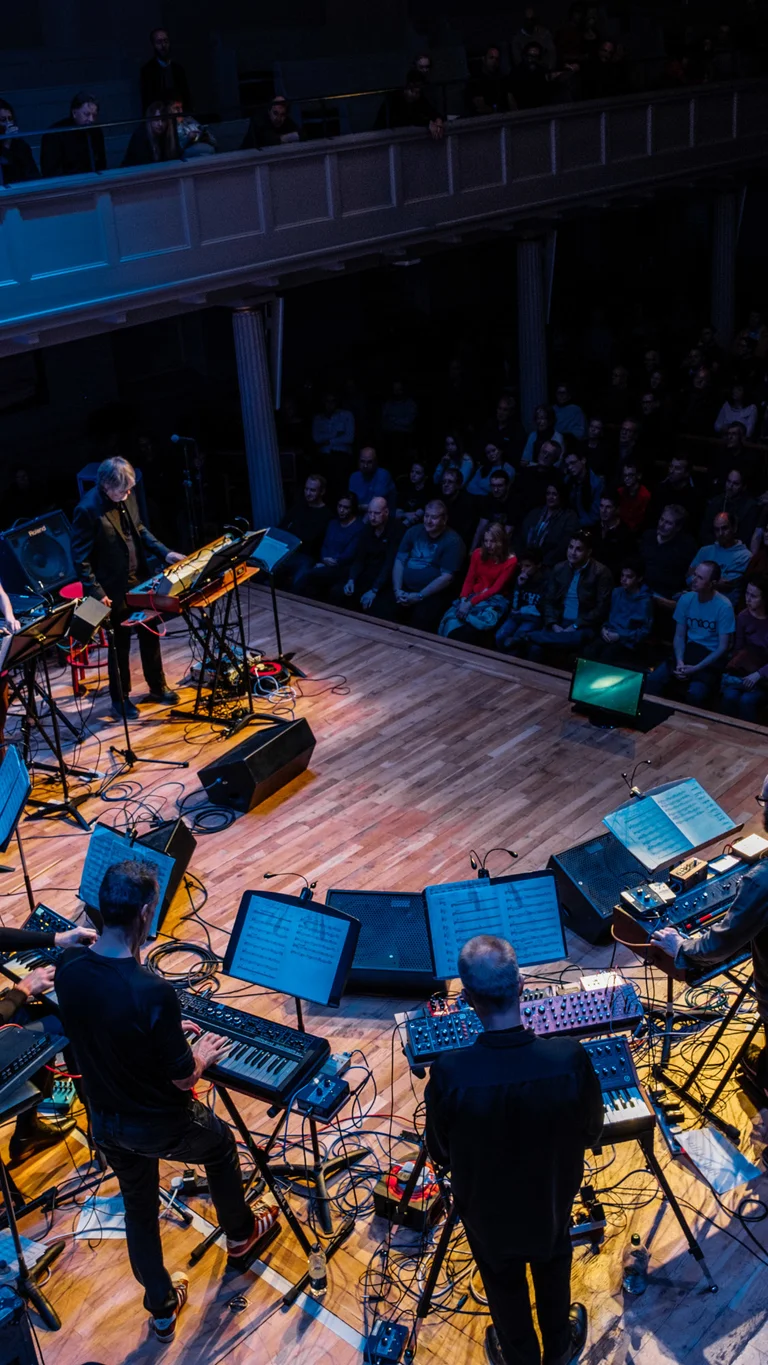 Das Syntheziser-Ensemble Will Gregory Moog bei einem Konzert vor Publikum.