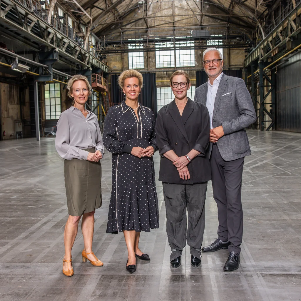 Four people at the Jahrhunderthalle Bochum. From left to right: Dr Vera Battis-Reese, Managing Director of Kultur Ruhr GmbH; Ina Brandes, Minister for Culture and Science of the State of North Rhine-Westphalia; Lydia Steier, Artistic Director of the Ruhrtriennale 2027–2029; and Garrelt Duin, Regional Director of the Regionalverband Ruhr