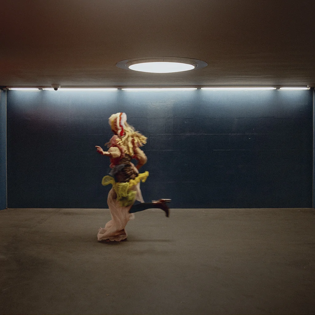 Eine kostümierte Figur, die durch eine unterirdische U-Bahn-Station läuft