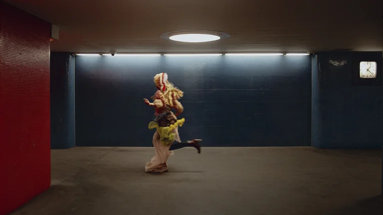 Eine kostümierte Figur, die durch eine unterirdische U-Bahn-Station läuft