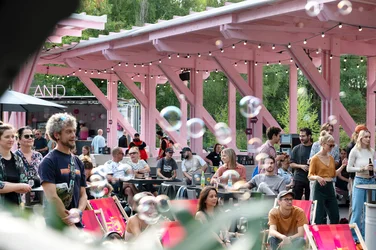 People are standing or sitting relaxed in the Wunderland festival centre, with soap bubbles floating through the air.