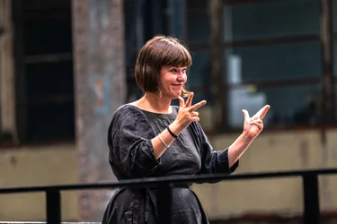 Dolmetscherin Konstanze Bustian übersetzt die Diskursveranstaltung "Brave New Voices" mit Autorin und Dramatikerin Sivan Ben Yshai bei der Ruhrtriennale 2024 in Deutsche Gebärdensprache.