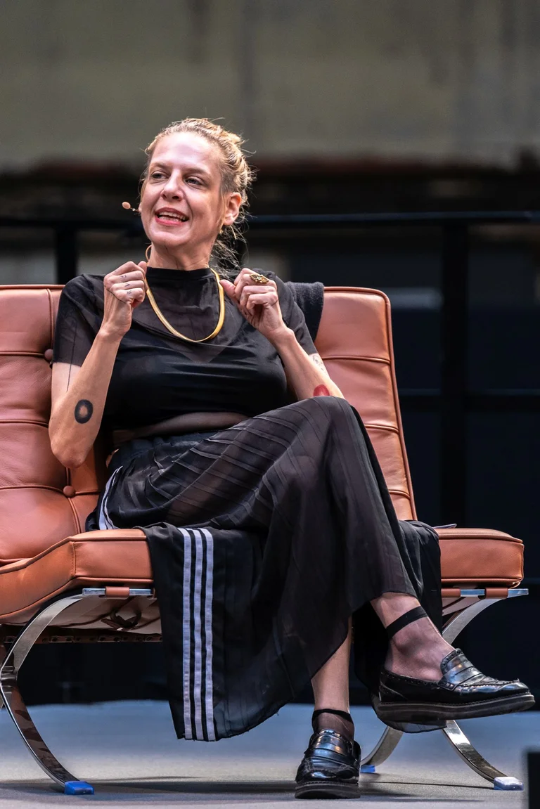 Sivan Ben Yishai in conversation on a chair in the Jahrhunderthalle, Bochum