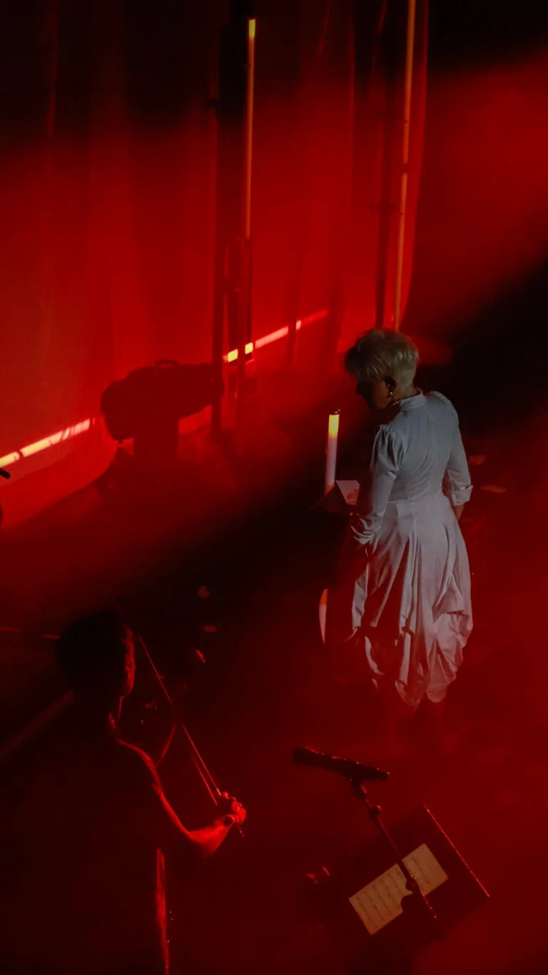 JoyceDiDonato und die drei Musiker von Time for Three stehen auf einer dramatisch rot beleuchteten Bühne.
