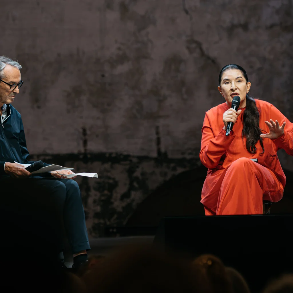 Ruhrtriennale-Intendant Ivo Van Hove und Marina Abramović sitzen sich auf einer Bühne gegenüber.