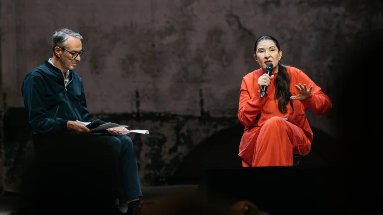 Ruhrtriennale-Intendant Ivo Van Hove und Marina Abramović sitzen sich auf einer Bühne gegenüber.