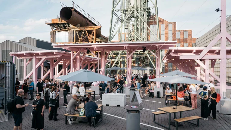 People enjoy an outdoor event at the festival centre Wunderland, with sunlight creating a warm atmosphere.