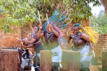 Three trummers strike their instruments, with movement, rhythm, and group dynamics defining the scene.