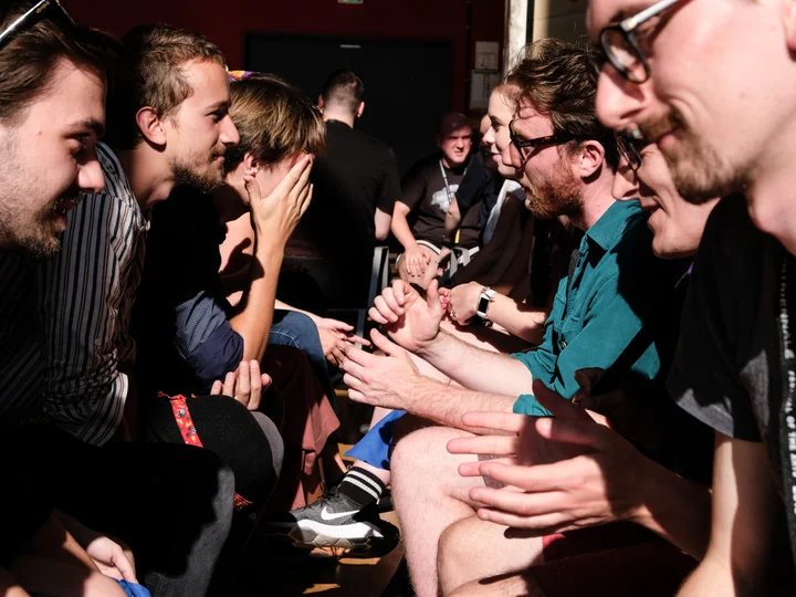 Close-up of a group of young adults sitting opposite each other.