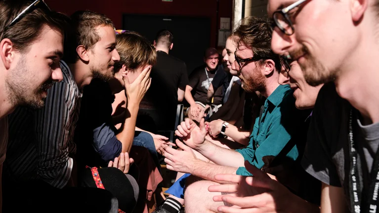 Close-up of a group of young adults sitting opposite each other.