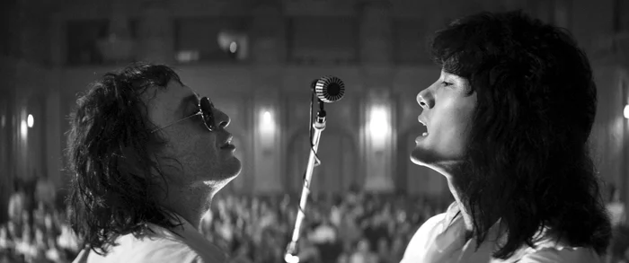 Schwarz-weiß Film still aus dem Film "Leto", auf dem zwei Personen in ein Mikrofon singen.