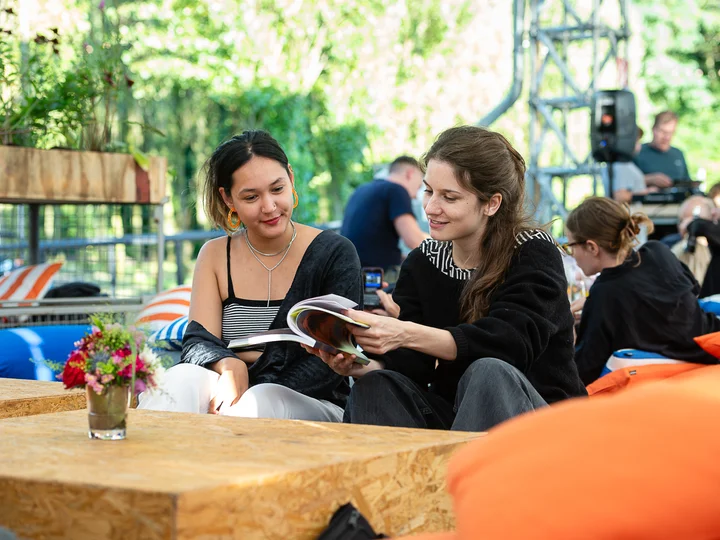 Two visitors on beanbags reading the Ruhrtriennale programme brochure.