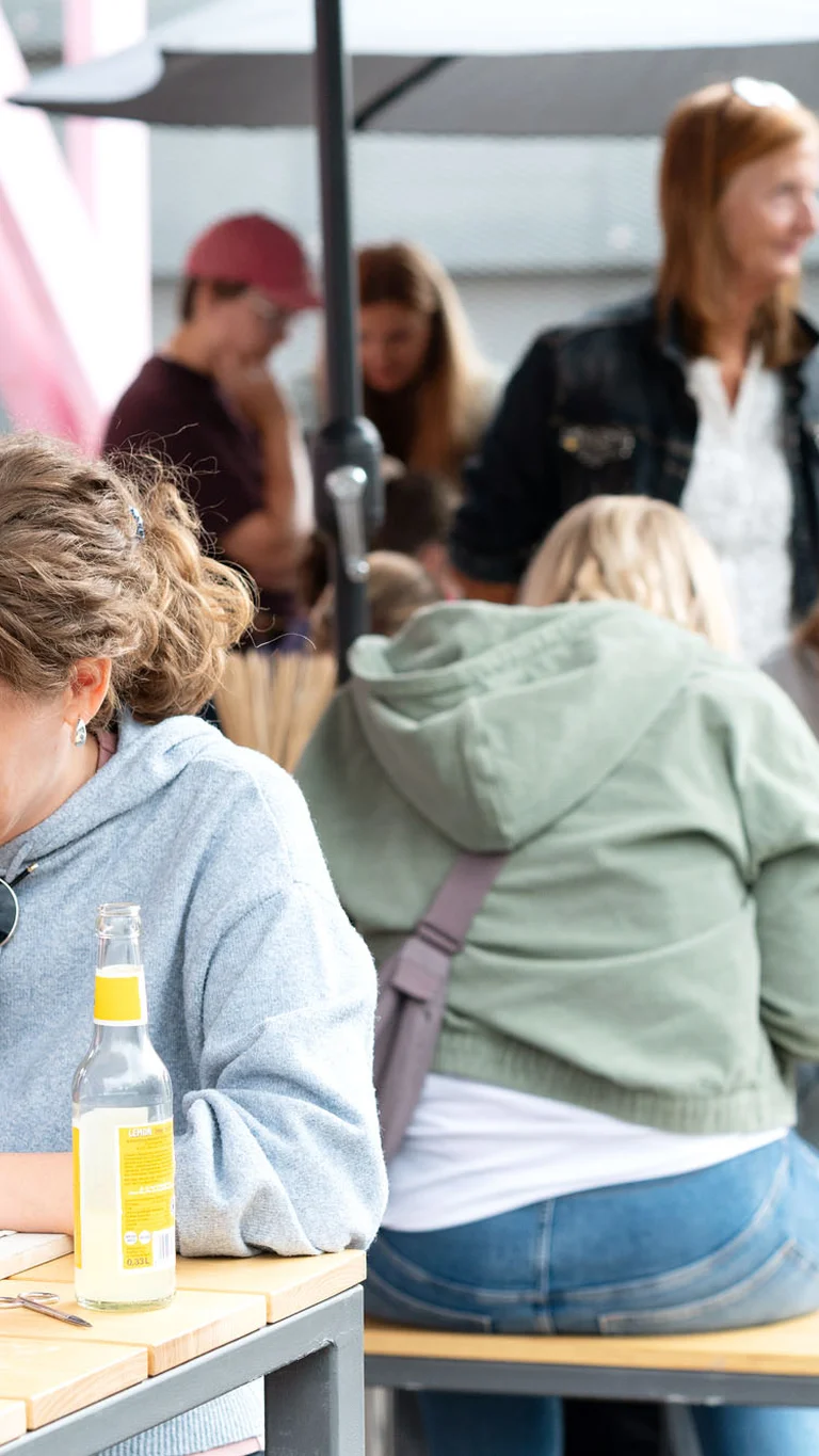 Menschen sitzen an Tischen und basteln kleine Gegenstände aus Ton.