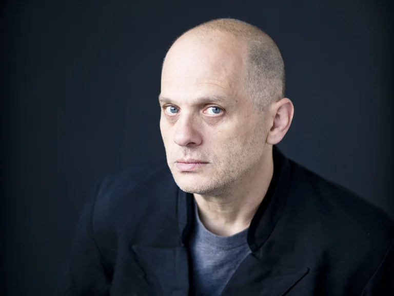 Portrait of David Lang in front of a dark background.