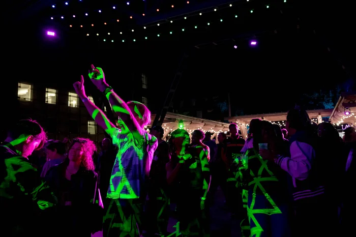 Visitors dance under colourful lights at a night-time party at the Ruhrtriennale festival centre.