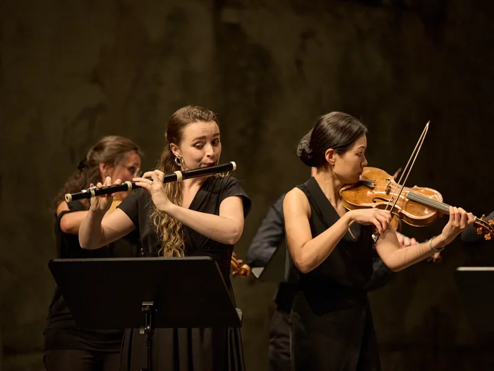 Zwei Musikerinnen spielen Querflöte und Geige auf der Bühne.