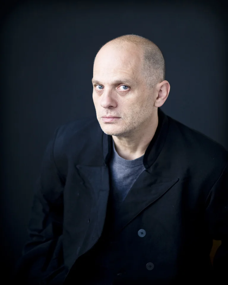 Der Komponist David Lang trägt dunkle Kleidung und schaut vor einem schwarzen Hintergrund ernst in die Kamera. Auf dem Portraitfoto ist er nur vom Oberkörper aufwärts zu sehen.